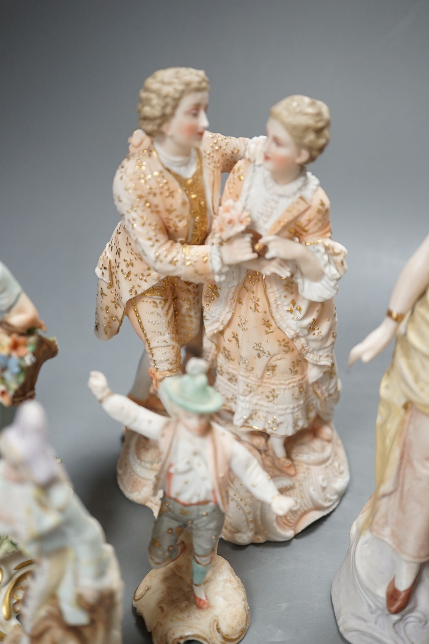 Ten French bisque figures and a Berlin figure of a grape picker, tallest 19cms high.